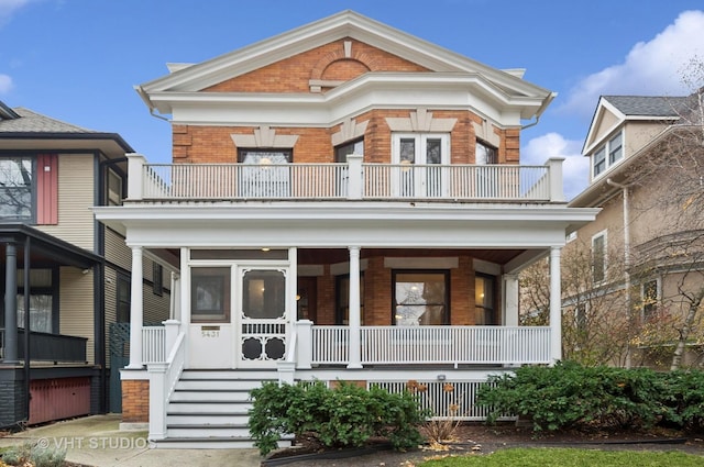 greek revival house featuring covered porch and a balcony