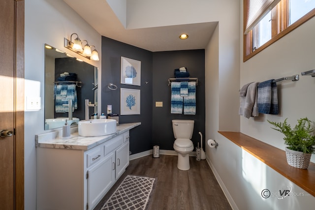 bathroom with toilet, wood-type flooring, and vanity