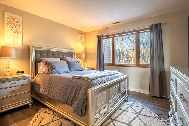 bedroom featuring a textured ceiling and dark hardwood / wood-style floors