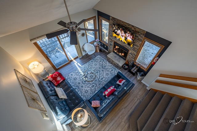 living room with ceiling fan, a fireplace, hardwood / wood-style floors, and high vaulted ceiling