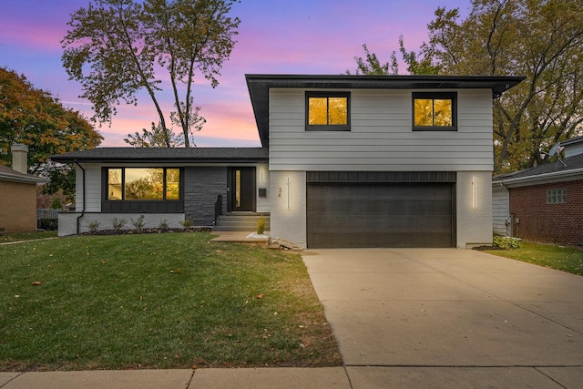 view of front facade with a garage and a lawn