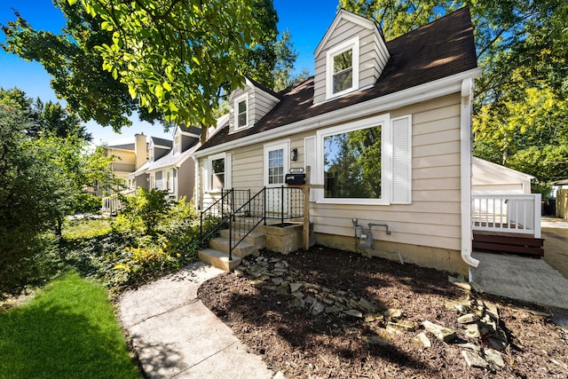 new england style home with a garage and an outbuilding