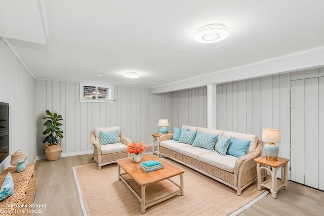 living room with light wood-type flooring and wooden walls