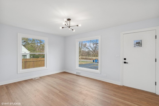 interior space featuring a notable chandelier and light hardwood / wood-style flooring