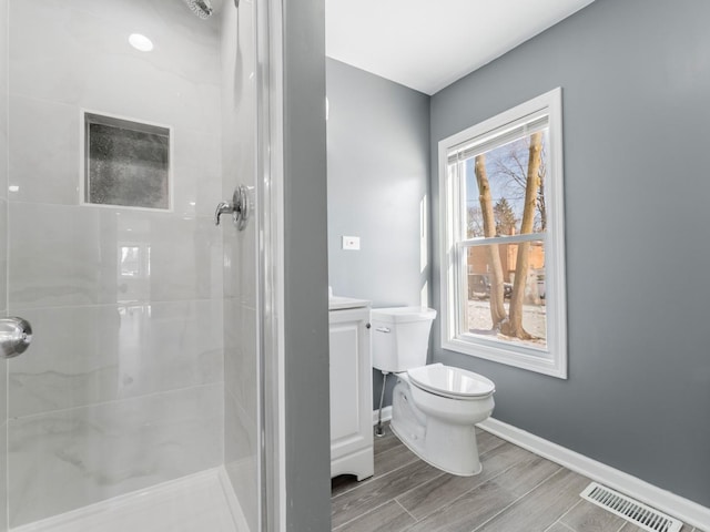 bathroom featuring walk in shower, toilet, and plenty of natural light