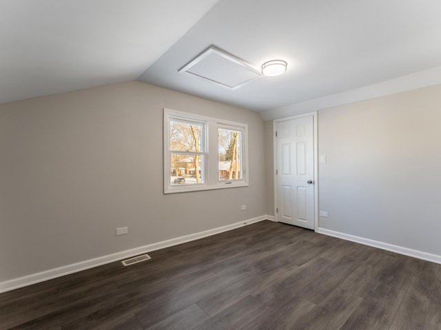 empty room featuring dark hardwood / wood-style floors and vaulted ceiling