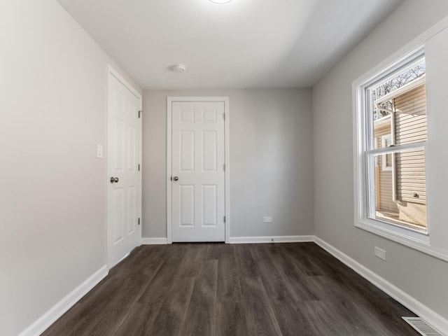 spare room with dark wood-type flooring