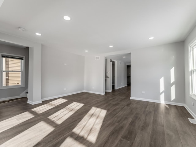 unfurnished room featuring dark hardwood / wood-style flooring and plenty of natural light