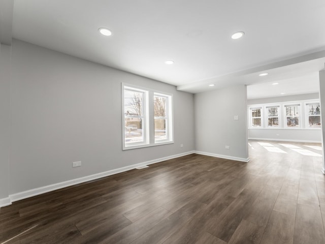 unfurnished living room featuring dark hardwood / wood-style flooring and plenty of natural light