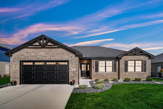 view of front of property with a garage and a lawn