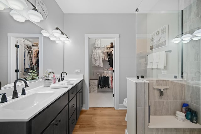 bathroom featuring a shower with shower door, wood-type flooring, toilet, and vanity