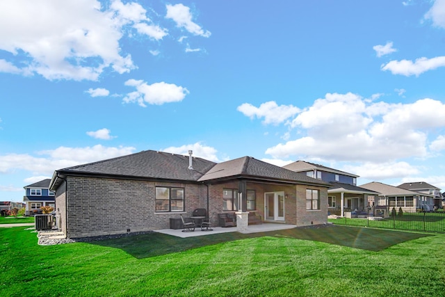 rear view of house featuring a lawn, central AC, and a patio area