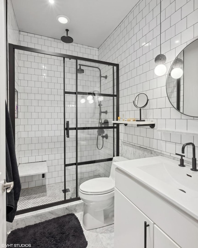 bathroom with tasteful backsplash, an enclosed shower, toilet, vanity, and tile walls