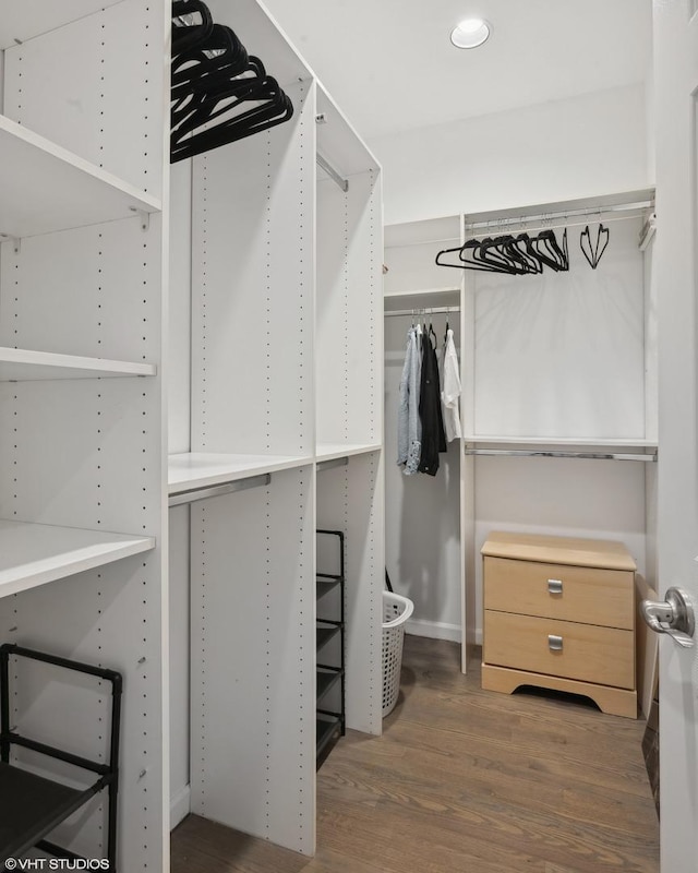 walk in closet with dark wood-type flooring