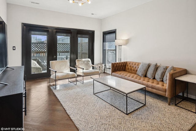 living room featuring french doors and an inviting chandelier