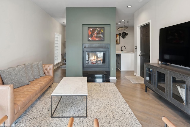 living room with light wood-type flooring and sink