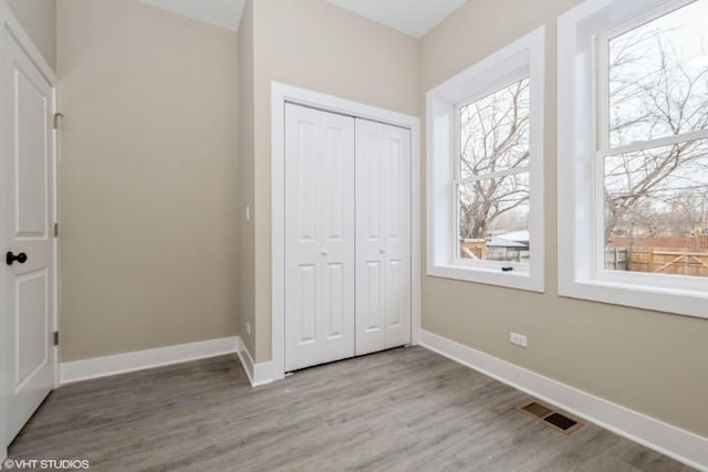 unfurnished bedroom featuring light hardwood / wood-style floors and a closet