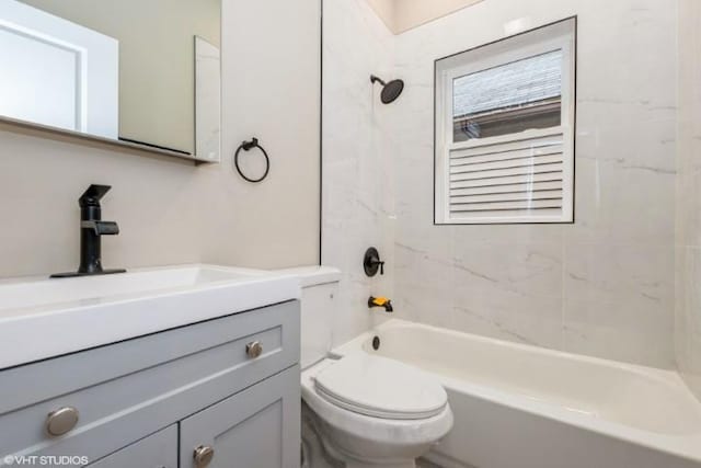 full bathroom featuring tiled shower / bath combo, toilet, and vanity