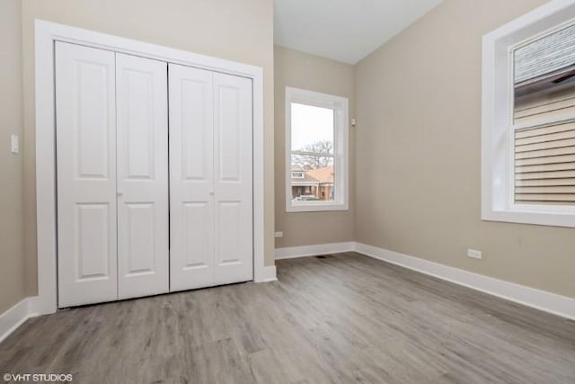 unfurnished bedroom featuring light hardwood / wood-style floors and a closet