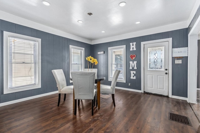 dining room with dark wood-type flooring and a healthy amount of sunlight