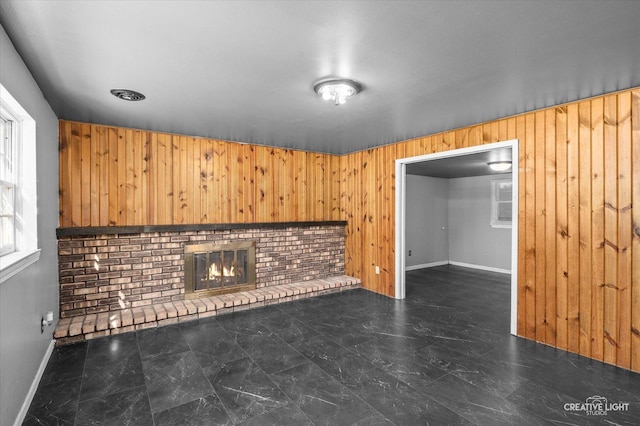 unfurnished living room featuring wooden walls and a fireplace