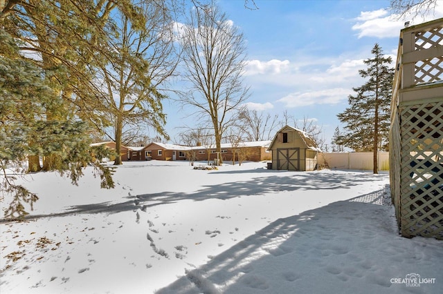 yard layered in snow with a shed