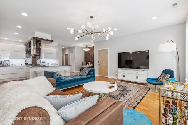 living room featuring light wood-type flooring and a chandelier