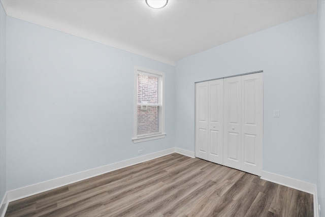 unfurnished bedroom featuring hardwood / wood-style floors and a closet