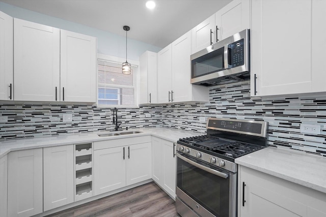 kitchen with tasteful backsplash, sink, white cabinets, and stainless steel appliances