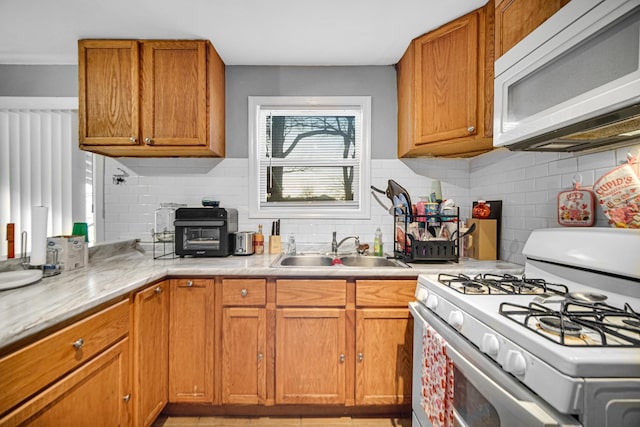 kitchen featuring backsplash, sink, and white appliances