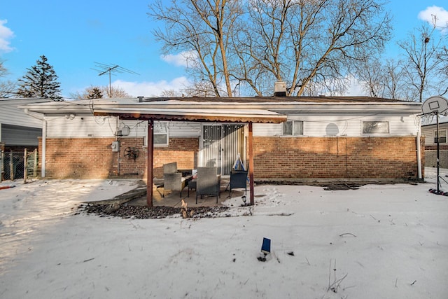 view of snow covered back of property