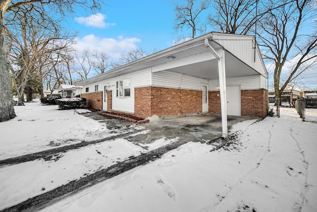 view of snowy exterior featuring a carport