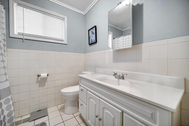 bathroom with vanity, tile patterned flooring, toilet, ornamental molding, and tile walls