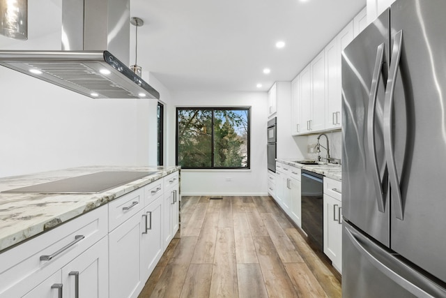 kitchen with black appliances, island exhaust hood, white cabinets, sink, and pendant lighting