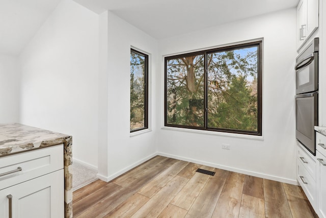 unfurnished dining area featuring light hardwood / wood-style floors