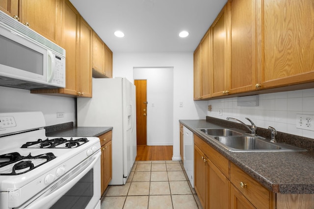 kitchen with light tile patterned flooring, white appliances, and sink