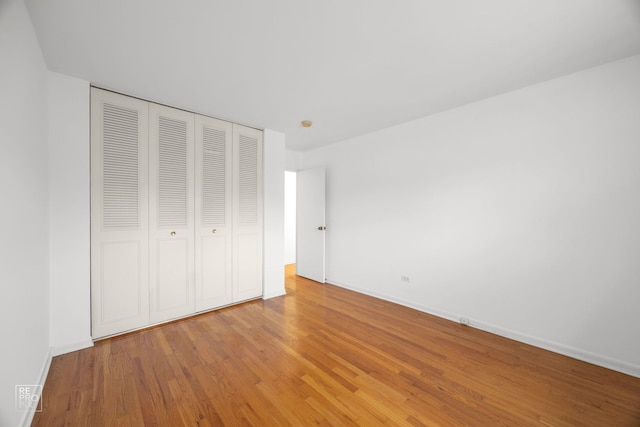 unfurnished bedroom featuring wood-type flooring and a closet