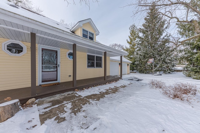 view of snow covered exterior featuring a garage