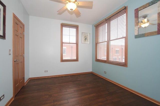 spare room with ceiling fan and dark wood-type flooring