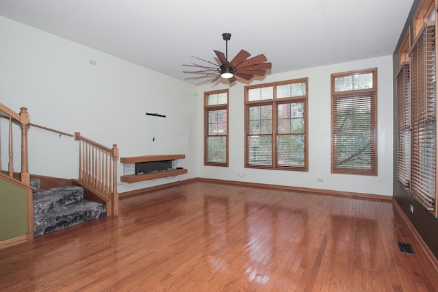 unfurnished living room featuring ceiling fan and light hardwood / wood-style floors