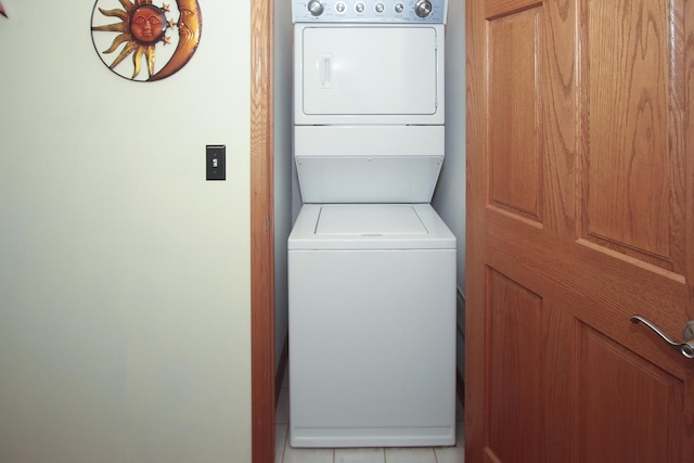 washroom with light tile patterned floors and stacked washer / dryer