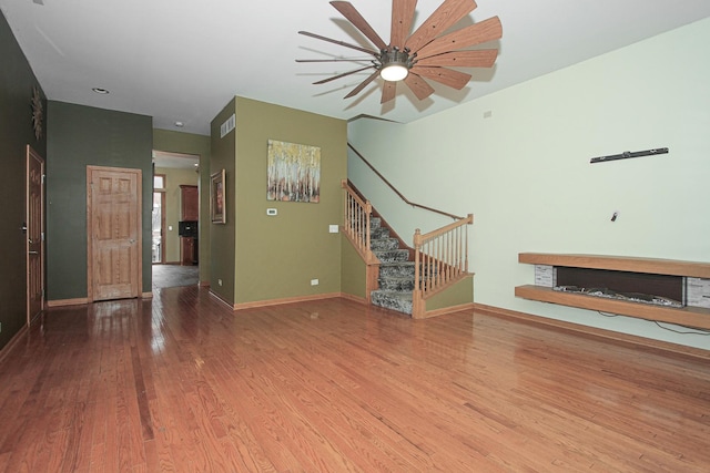 unfurnished living room featuring ceiling fan and hardwood / wood-style flooring