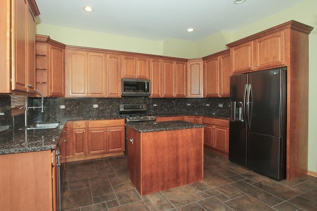 kitchen with a center island, dark stone countertops, sink, and appliances with stainless steel finishes