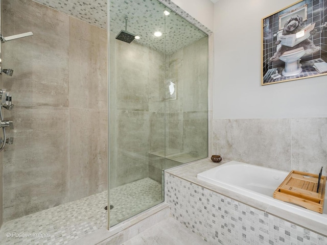 bathroom featuring a garden tub and tiled shower