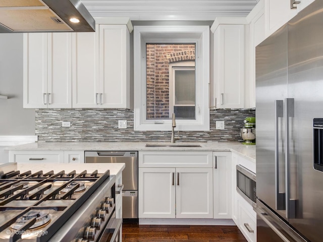 kitchen featuring island range hood, white cabinets, appliances with stainless steel finishes, light stone counters, and a sink