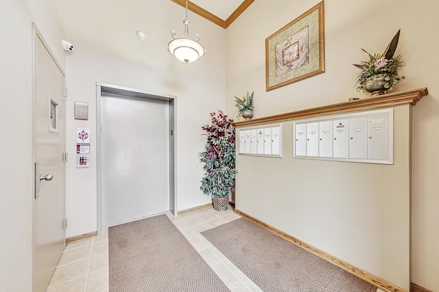 entrance foyer with light tile patterned floors, mail boxes, and ornamental molding