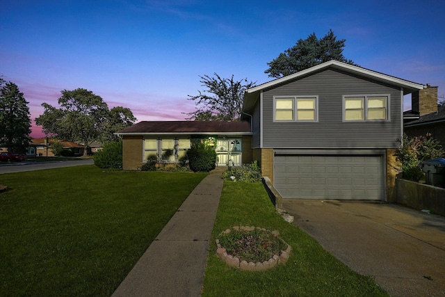 split level home featuring a lawn and a garage