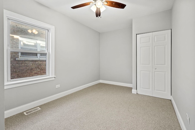 unfurnished bedroom with carpet, a closet, and ceiling fan