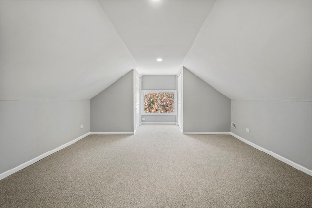 additional living space featuring carpet floors and vaulted ceiling