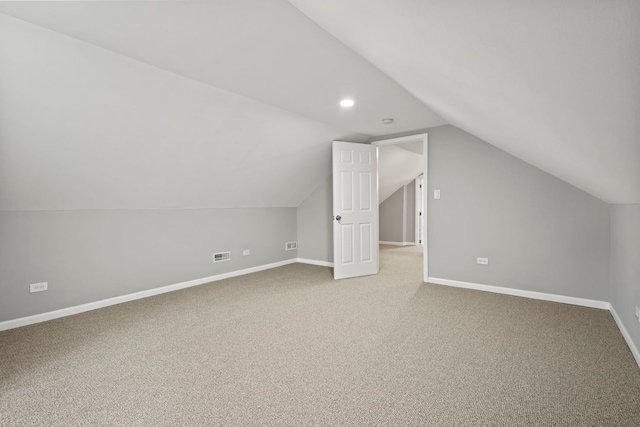 additional living space with carpet flooring and lofted ceiling